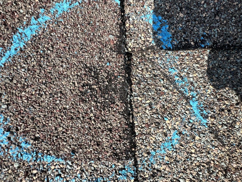 Close-up of hail impact damage on an asphalt shingle in Grapevine, TX