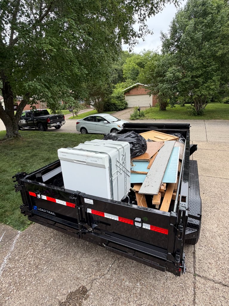 Dump trailer loaded and ready in residential driveway