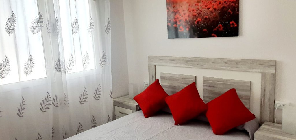 Habitación principal con cojines rojos