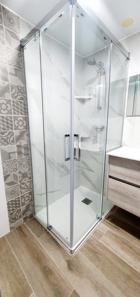 Baño con ducha esquinera de cristal