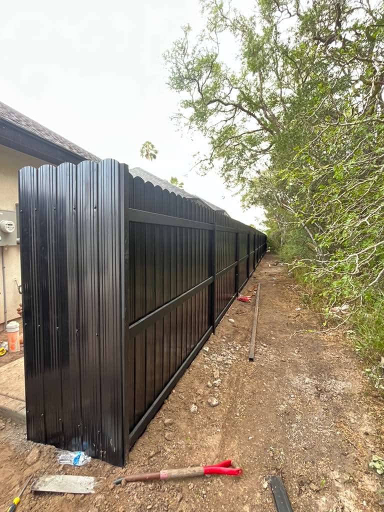 Black corrugated metal fence with scalloped top