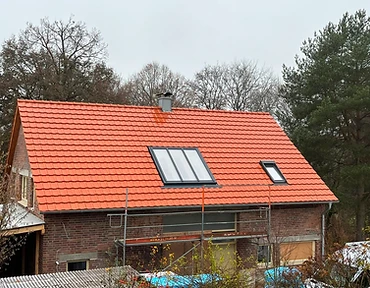 Neu eingedecktes Steildach mit roten Tondachziegeln