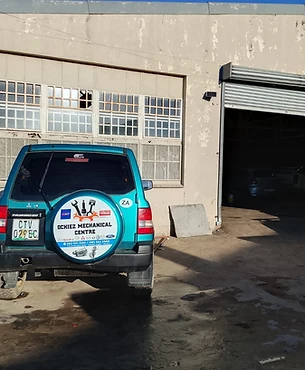 OCHIEZ branded Mitsubishi outside the workshop service bay