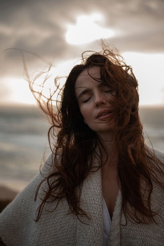 Kvinde ved havet med vinden i håret