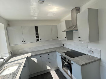 Kitchen after: light grey cabinets, stone-effect worktops and subway splashback