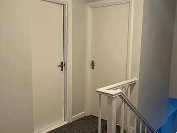 Landing after: white walls, white balustrade and new grey carpet