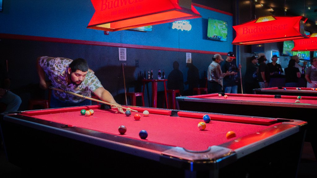 Pool tables under red neon lights inside Shorty’s Icehouse