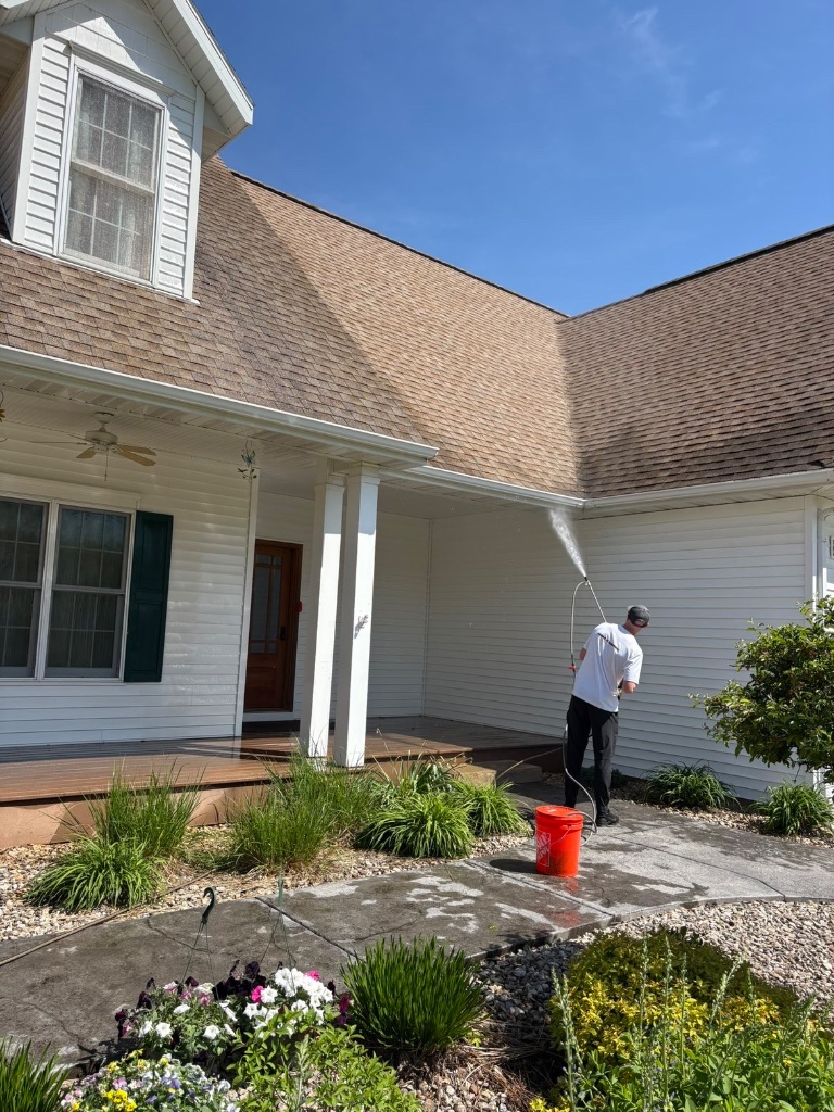 Twin Jet technician soft washing the siding of a Wisconsin home