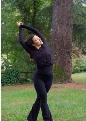 Mira stretching outdoors beneath a tree