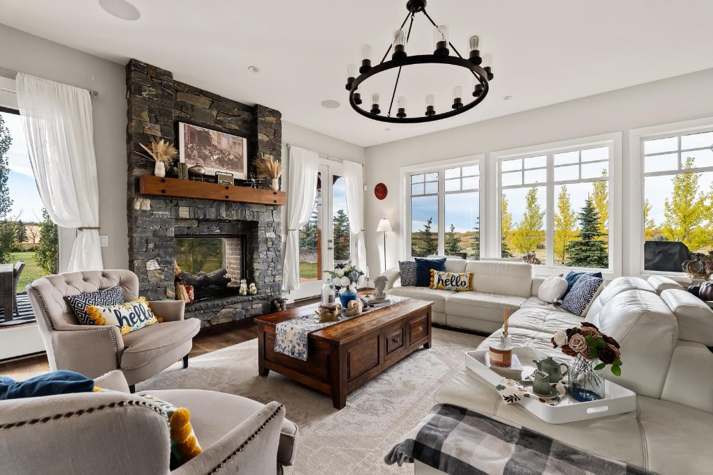 Double-sided stone gas fireplace in luxury mountain modern estate home — Bearspaw Alberta custom acreage property interior detail
