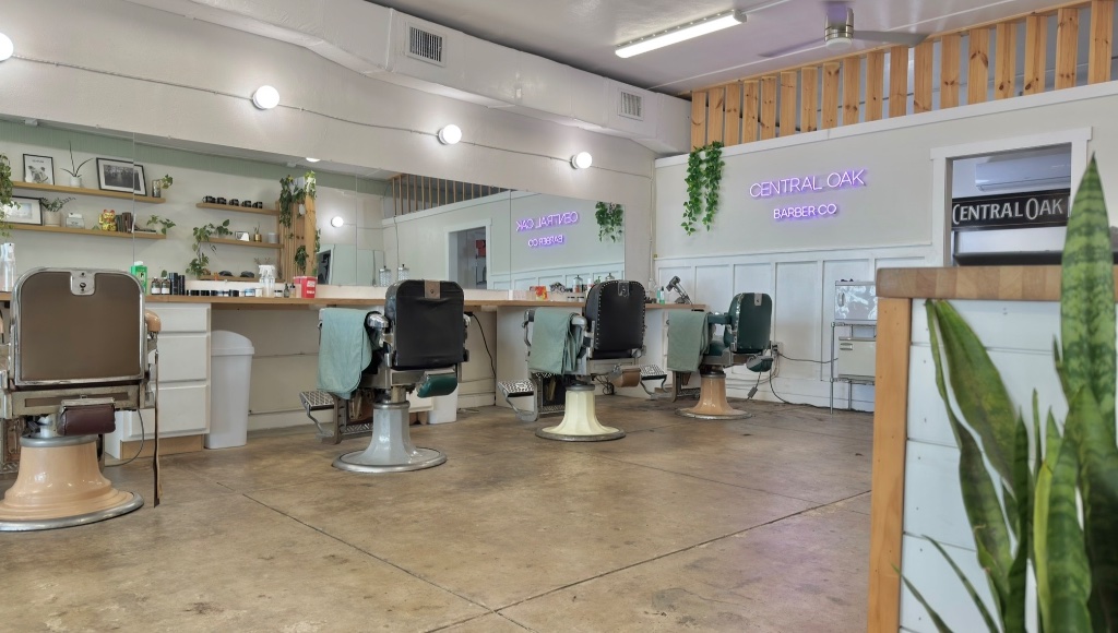 Wide view of Central Oak Barber Co. interior with barber working
