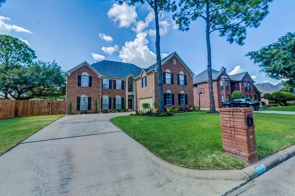 Front exterior of Hearthstone Houses, a two-story red-brick residence on Capri Circle, Houston