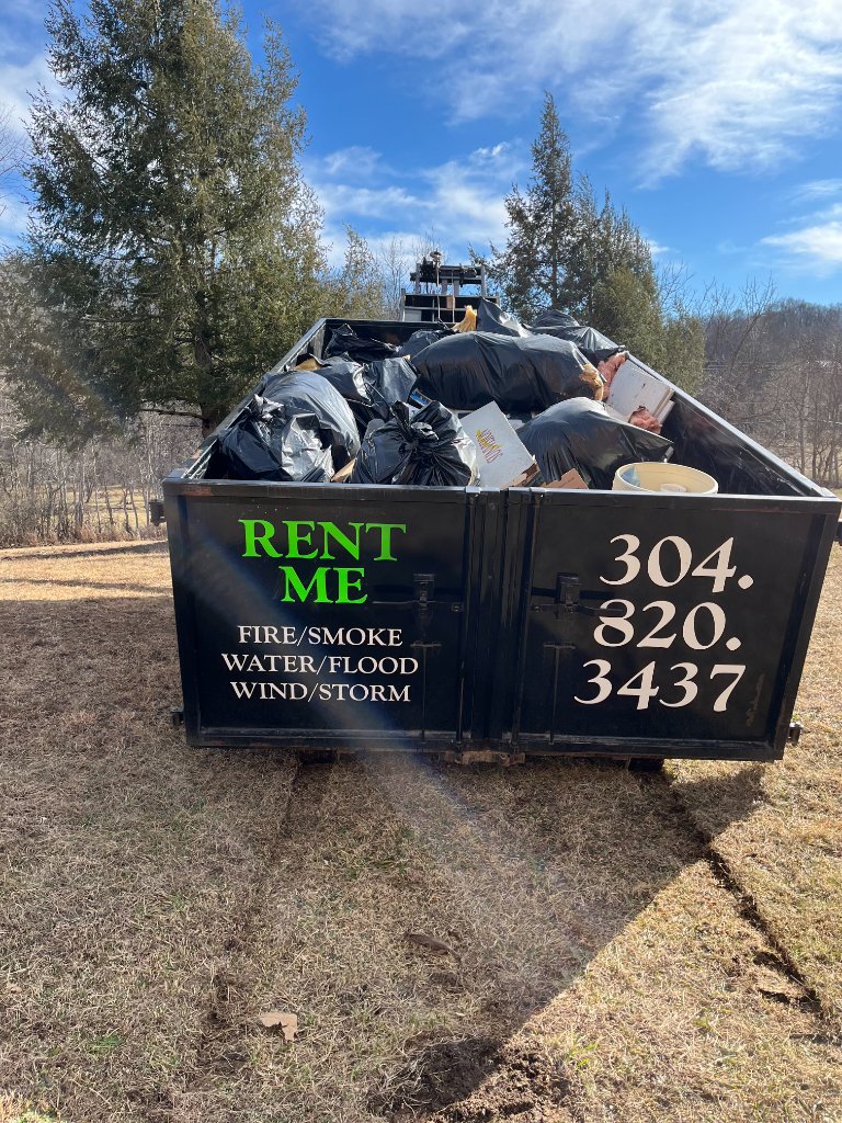 ZK Dumpster loaded with debris on gravel