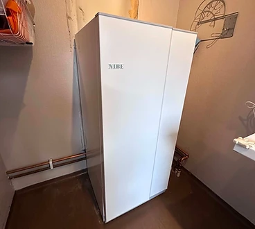 Installerad NIBE-enhet för värme och varmvatten med synlig rördragning.