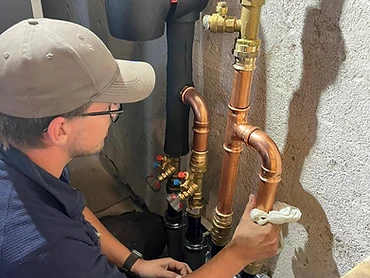 VVS-montör installerar kopparrör och ventiler i teknikrum