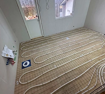 Vattenburen golvvärme med slingor av PEX-rör fästa på armeringsnät.