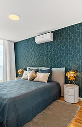 Primary bedroom with teal feature wall and ocean view