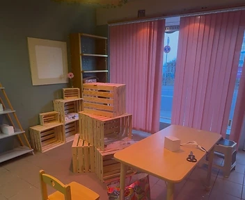 Der entstehende Raum mit Holztisch, Kinderstuhl und Regalen