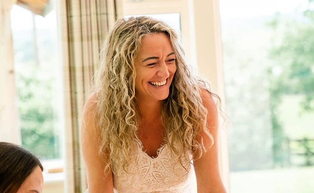 Terri Brown leaning forward against a light-wood table in a warm, professional setting.