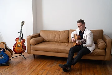 Tim Collins surrounded by his guitars