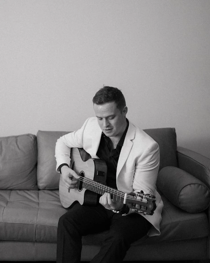 Tim Collins playing guitar in his studio