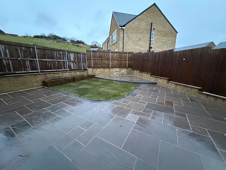 Two-tier slate patio and retaining wall project by JMB in Colne