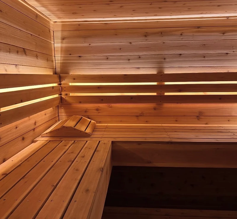 Steam rising in a dark cedar Nordic sauna