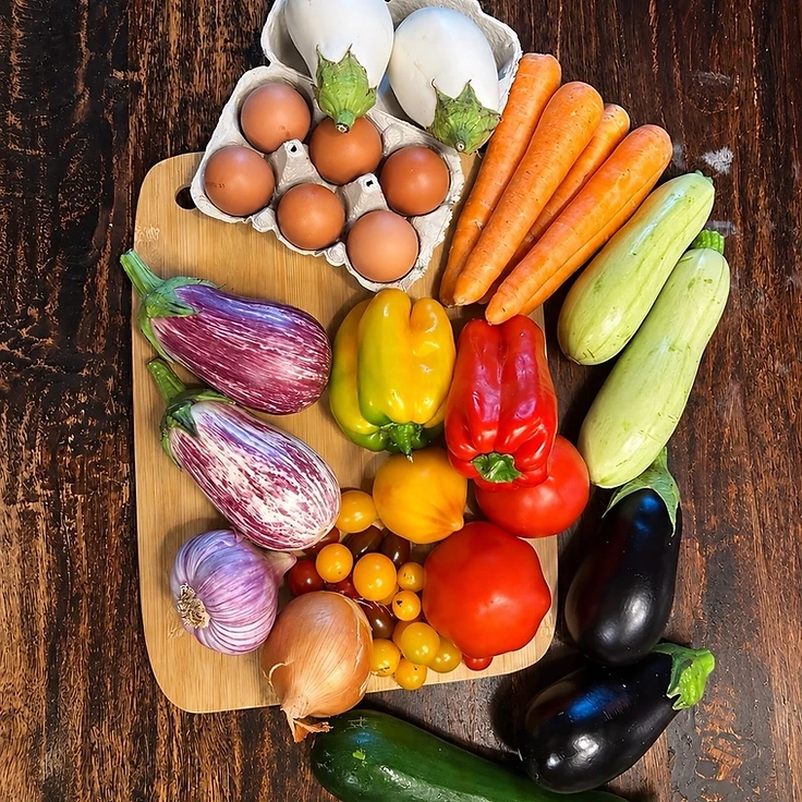 Légumes frais et œufs sur une planche en bambou