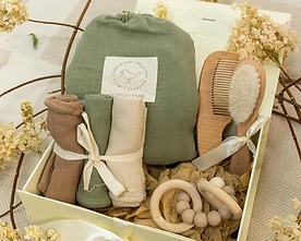 A soft cream gift box with sage and wood accents, surrounded by dried flowers