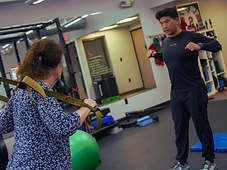 Migma Tamang guiding a client through a suspension training movement in the studio.