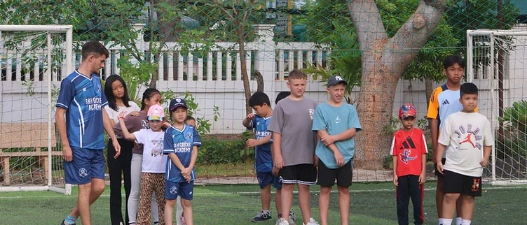 The full academy group lined up on the turf with their coach