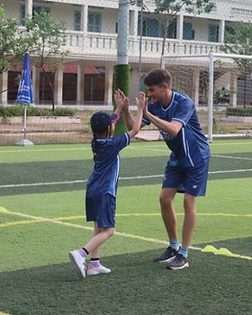 A coach and a young player celebrating with a high five