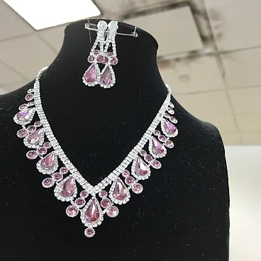 Crystal and pink stone necklace and earring set on black velvet bust