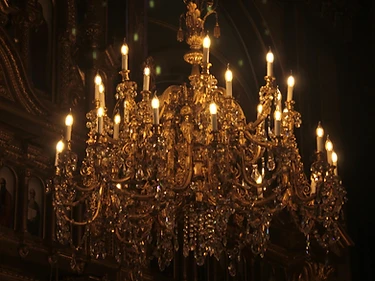 An antique crystal chandelier glowing against near-total blackness