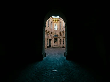 A shadowed archway lit by a single source