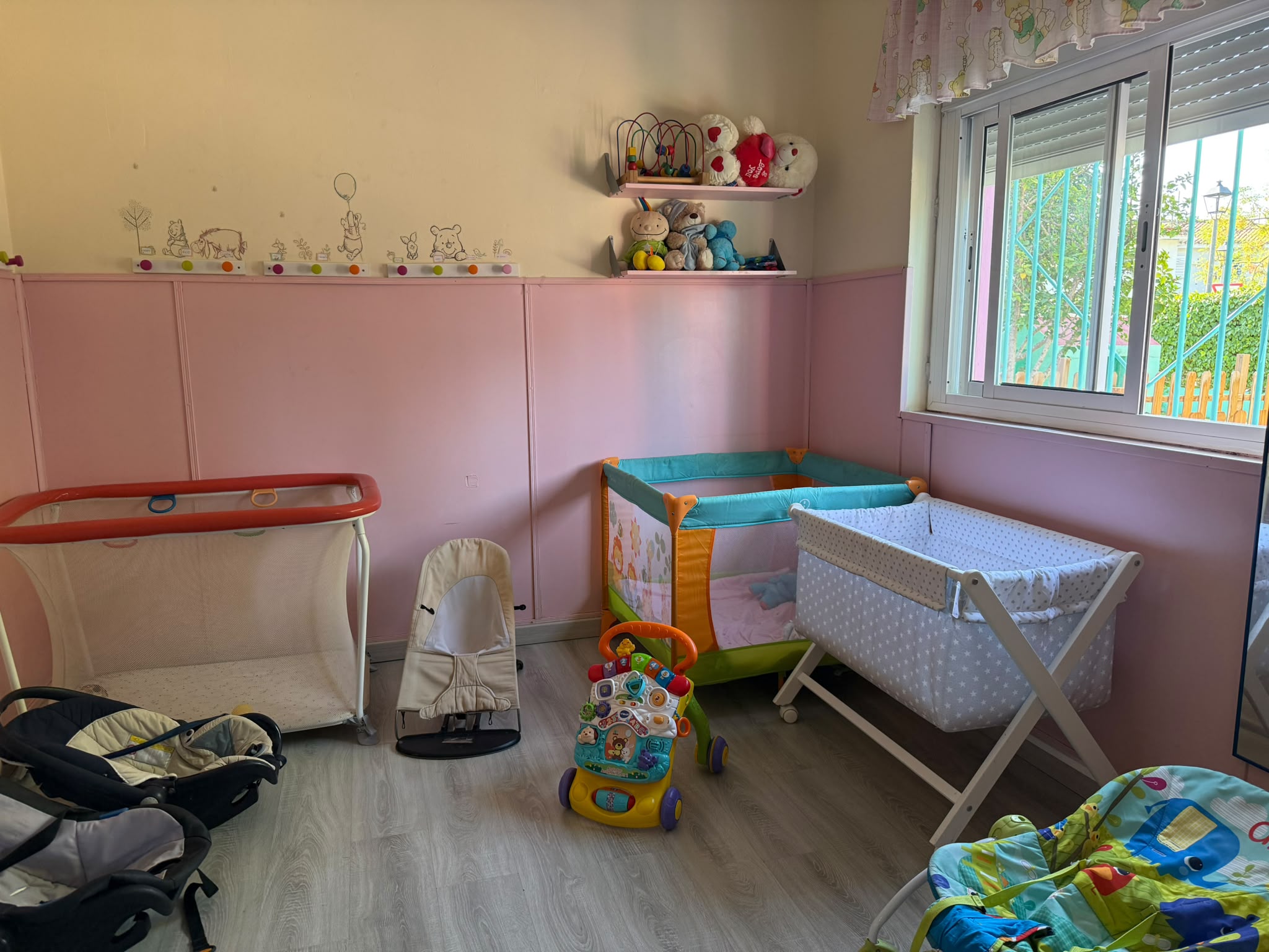 Aula del jardín de infancia con cunas, juguetes y estanterías decoradas