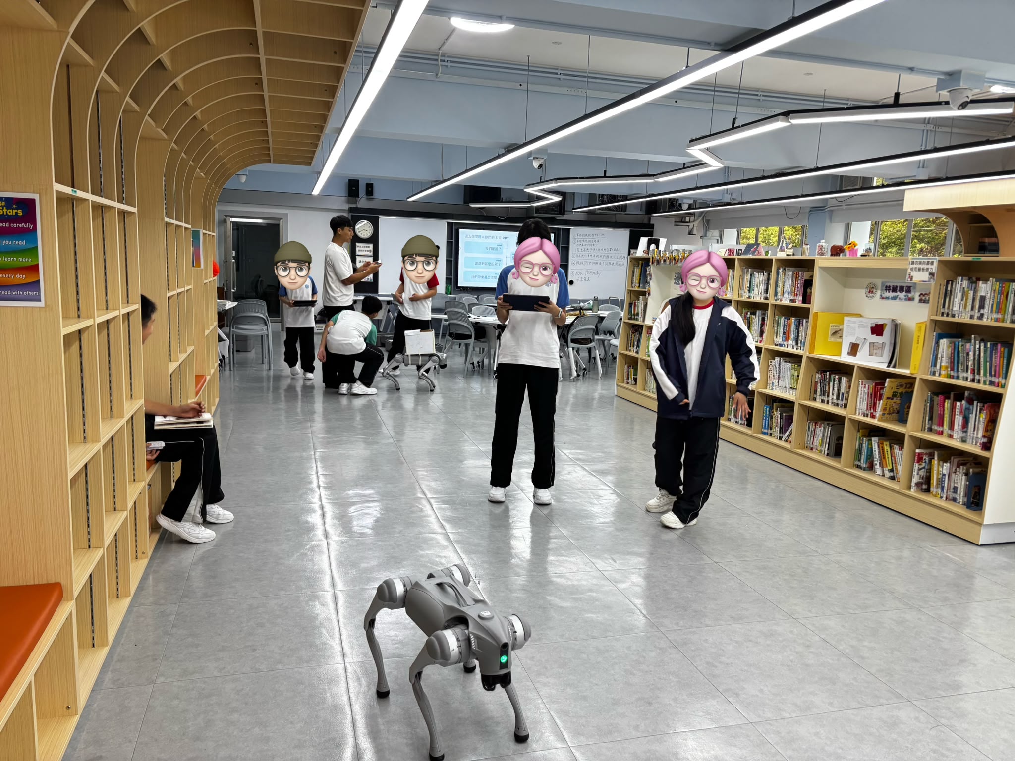 學生在圖書館手持平板編程，測試四足機械狗的行走路線