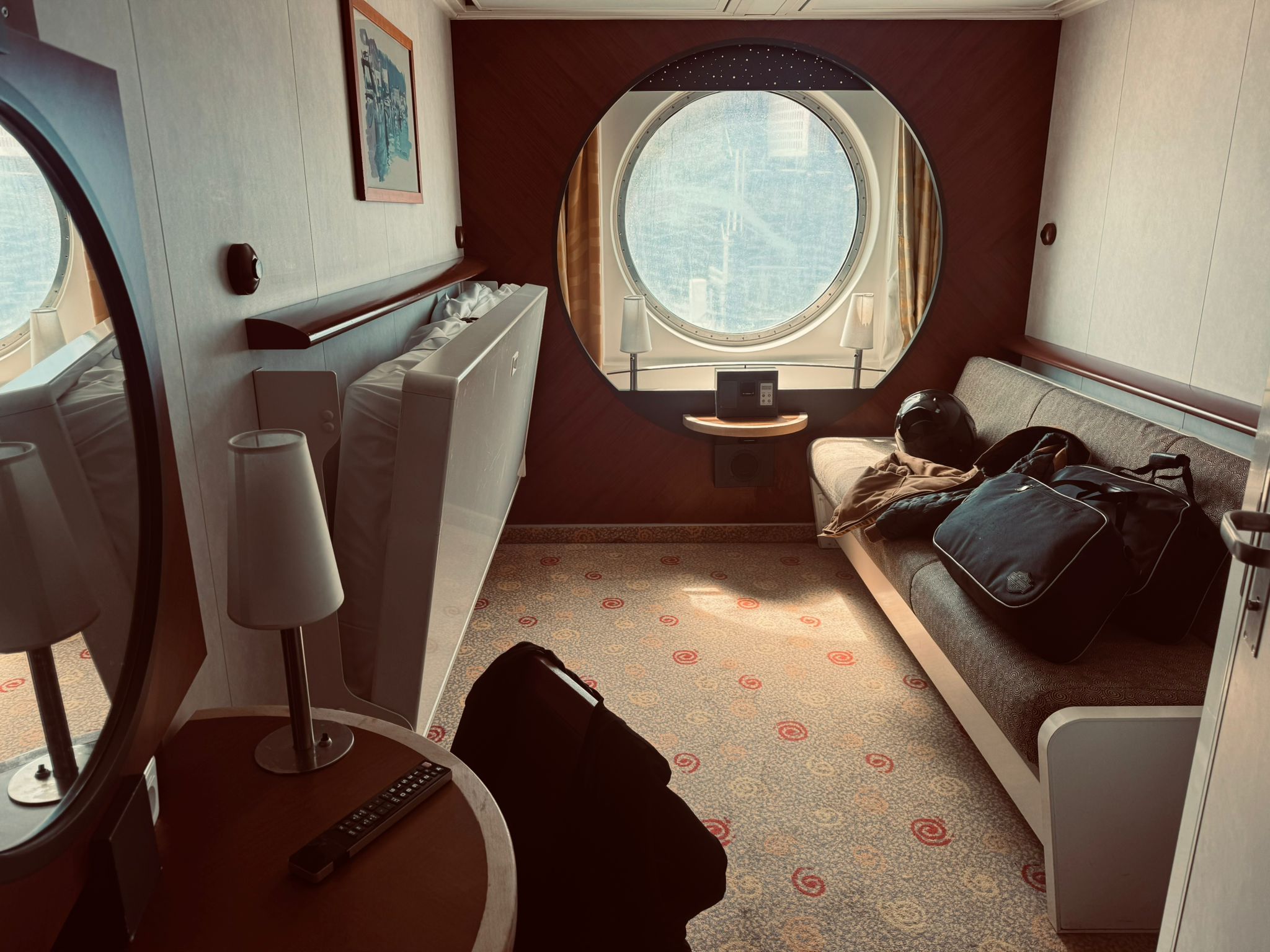 Brittany Ferries cabin on the Plymouth to Santander crossing — helmet and bags on the bunk, porthole window